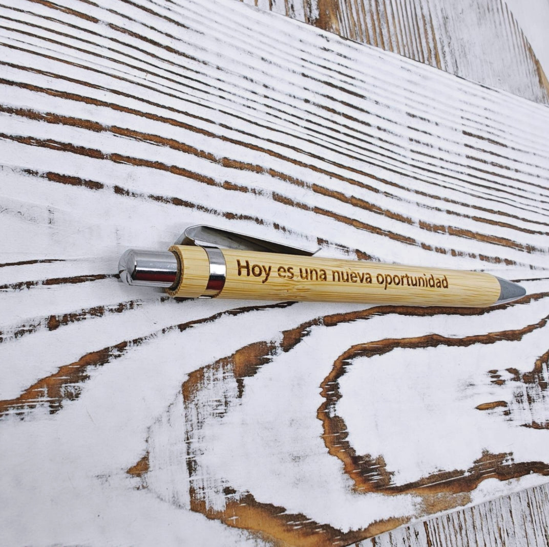 Bolígrafo retráctil de bambú con tinta negra y grabado láser de una frase inspiradora.
