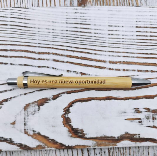 Bolígrafo de bambú con grabado láser de la frase "Hoy es una nueva oportunidad" y tinta negra.