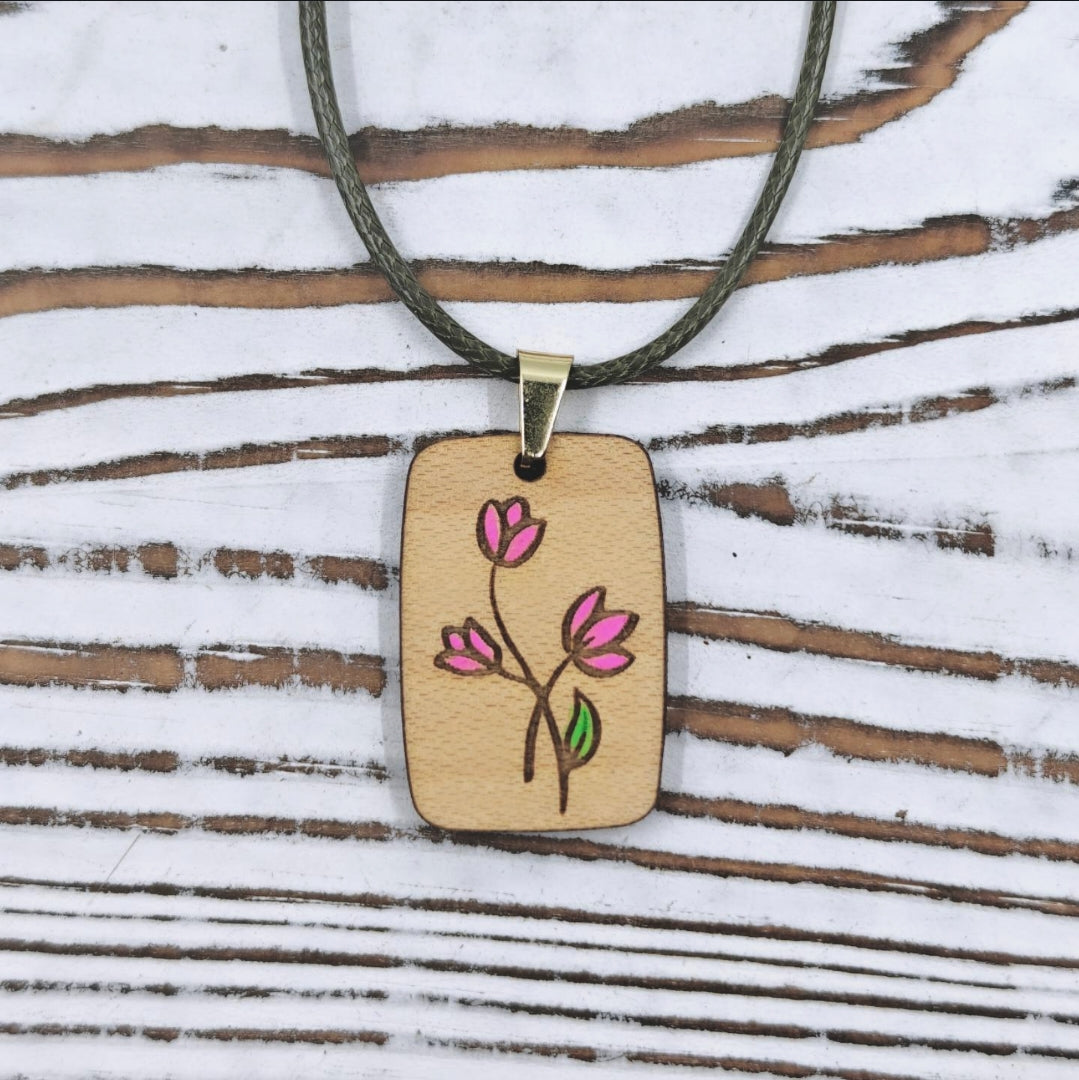 Collar de madera con diseño floral minimalista y detalles pintados a mano.