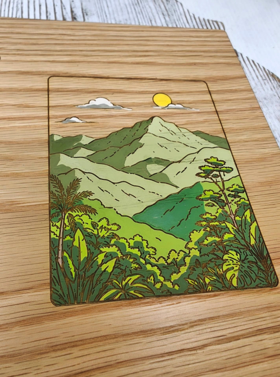 Detalle del diseño pintado a mano inspirado en el Bosque Nacional El Yunque sobre una libreta de madera de roble rojo.