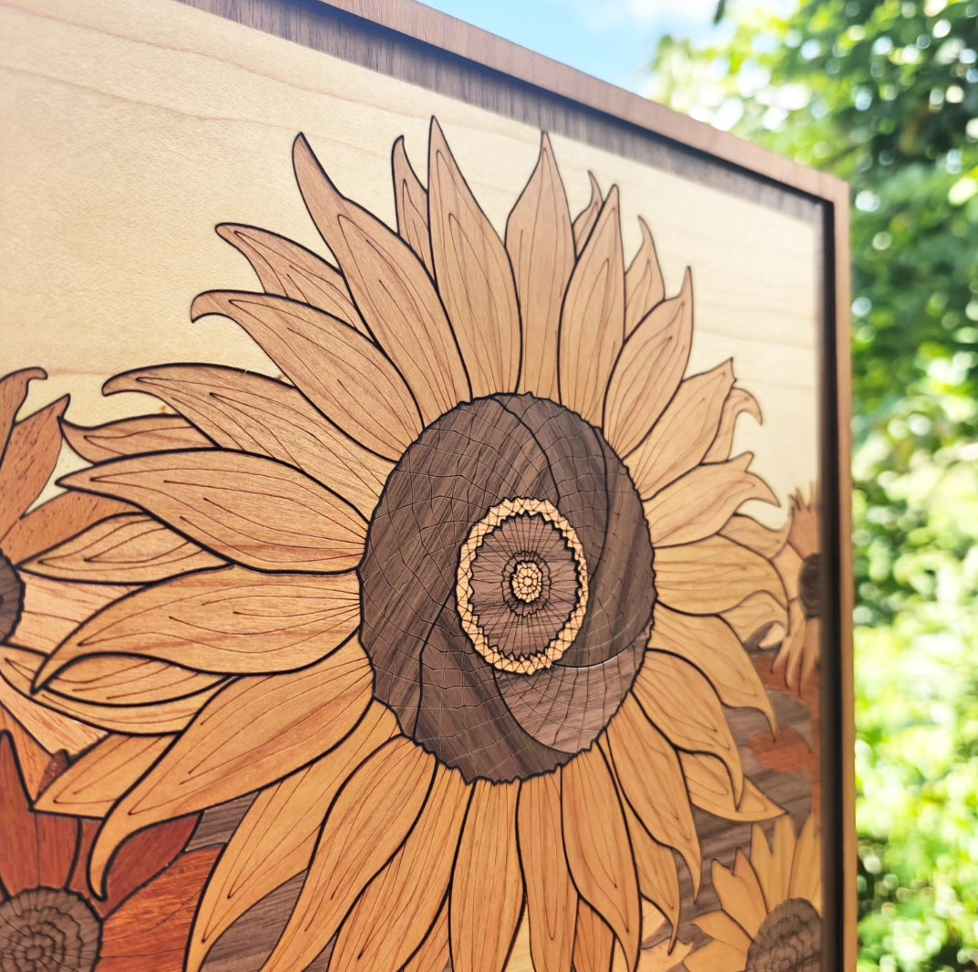 Cuadro de girasol tallado en madera con centro grabado capa por capa, mostrando marco de madera y granos naturales