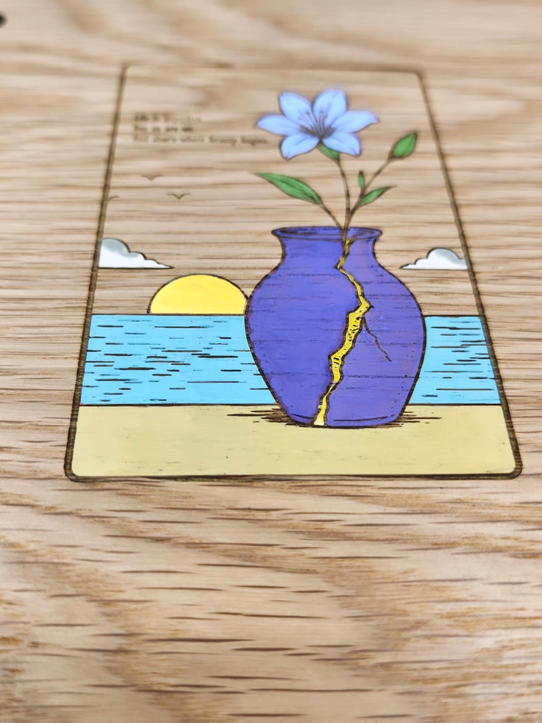 Detalle de la portada de madera pintada a mano con jarrón Kintsugi y atardecer.
