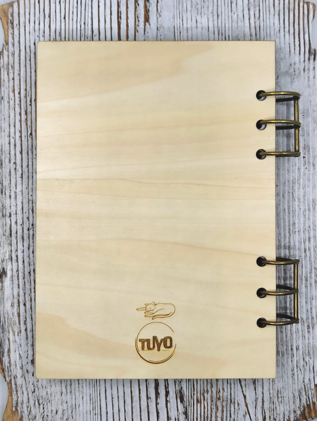 Contraportada de libreta de madera con logo Tuyo grabado y gato durmiendo