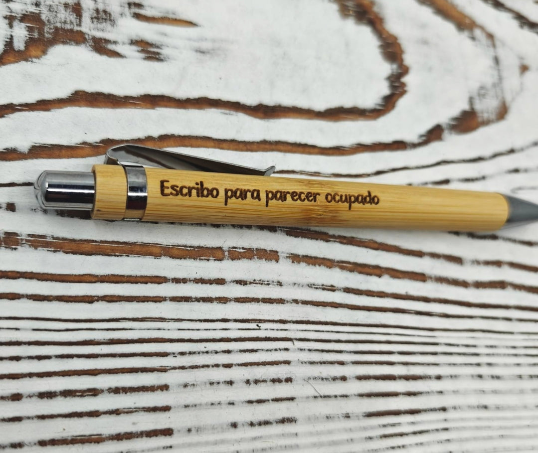Detalle del grabado láser en bolígrafo de bambú con la frase "Escribo para parecer ocupado"