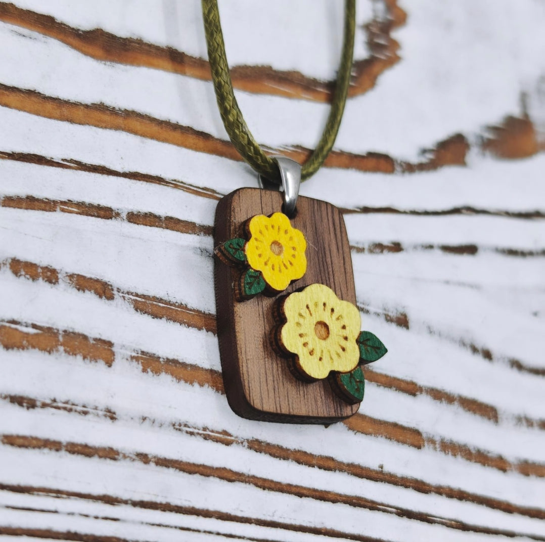 Detalle de collar de madera con flores en relieve pintadas a mano