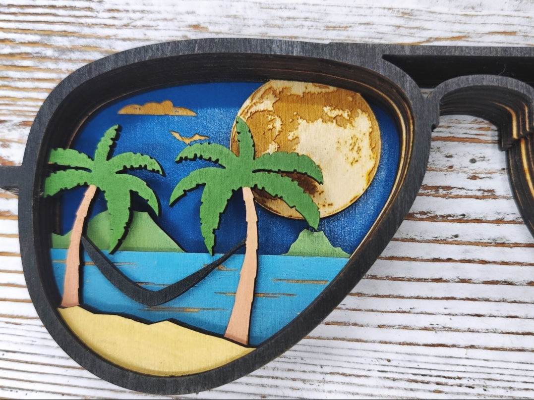 Detalle del lente izquierdo con escena de hamaca entre palmeras y luna llena dorada, arte de madera en capas hecho a mano